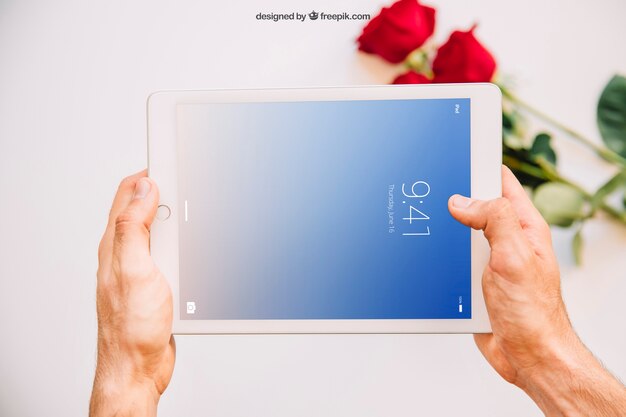 Modello di San Valentino con mani che tengono tablet