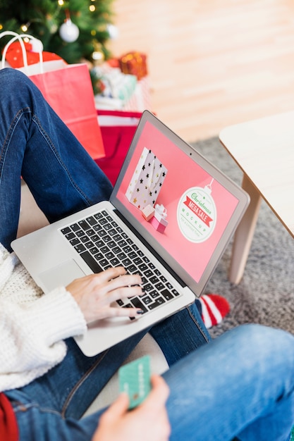 Modello di vendita di Natale con donna usando il portatile