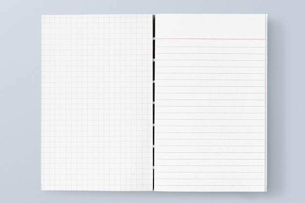 Modelo de cuaderno blanco y alineado en una mesa azul