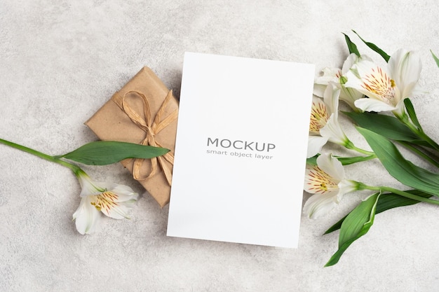 Modelo de cartão de saudação em branco com caixa de presentes e flores cartão branco com espaço para cópia