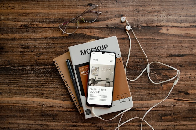 Modelo de livro de smartphone e revista em fundo de madeira