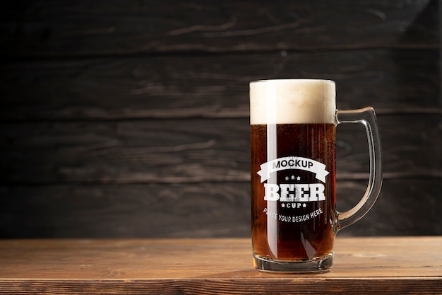 Modelo de xícara de cerveja em mesa de madeira