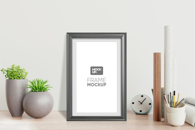 Moderno modello di cornice su una scrivania di legno con piante e accessori