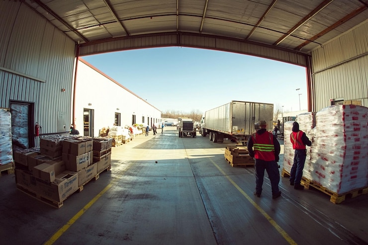 PSD el muelle de carga del almacén con trabajadores cargando y descargando mercancías de semitrucks