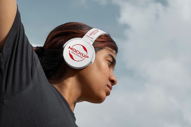 Mujer de ángulo bajo con auriculares