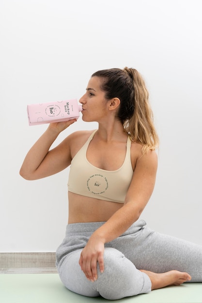 Mujer atlética bebiendo agua después del yoga