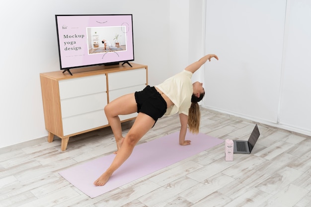 Mujer atlética haciendo yoga en casa