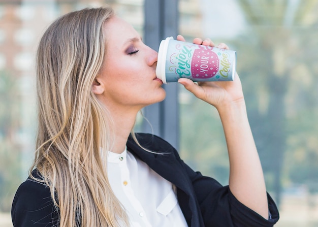 Mujer bebiendo café de vaso de plástico