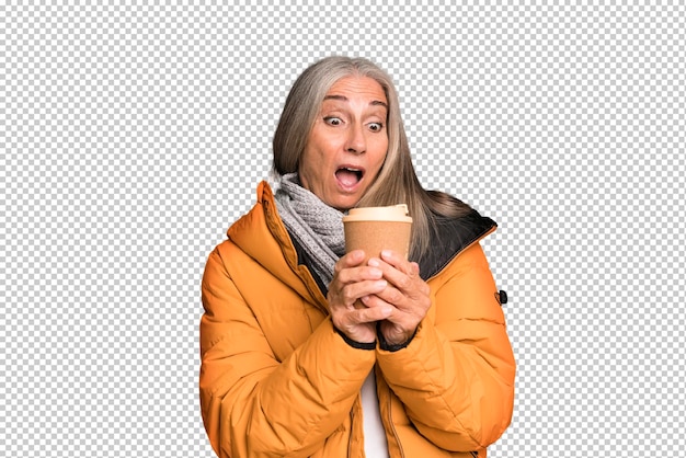 PSD mujer bonita senior de cabello gris con un anorak con un café caliente para llevar en invierno y un concepto frío