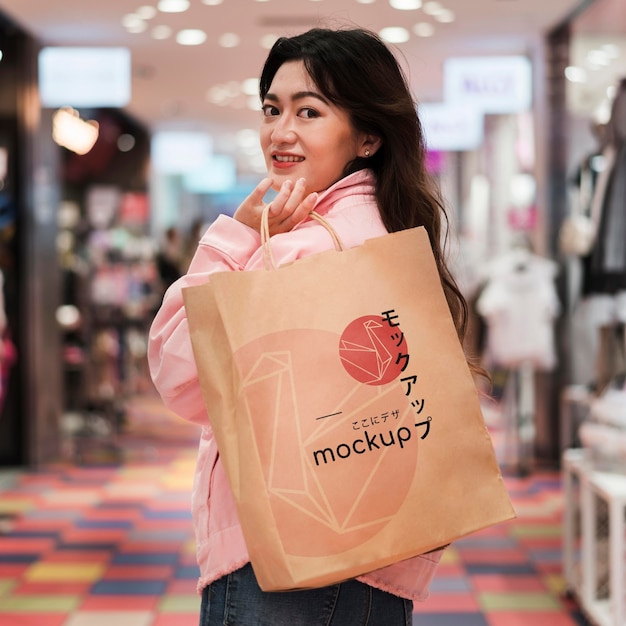 Mujer caminando en el centro comercial con bolsa de compras tiro medio