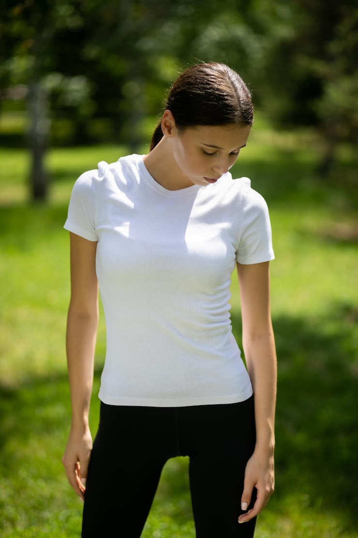 PSD mujer en camiseta blanca y leggings negras al aire libre