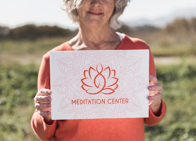 Mujer con un cartel de logotipo del centro de meditación