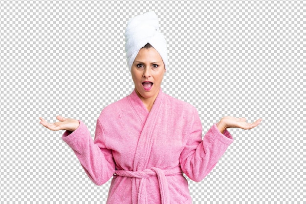 PSD mujer caucásica de mediana edad en bata de baño sobre un fondo aislado con expresión facial conmocionada