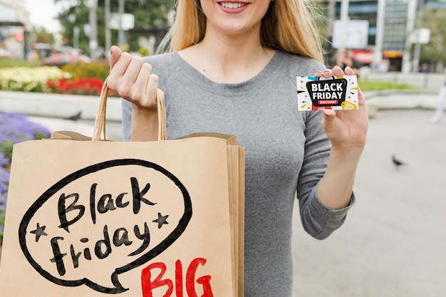 Mujer en ciudad con bolsas de black friday