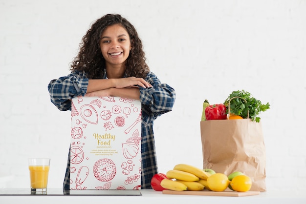 Mujer en cocina con frutas y verduras saludables