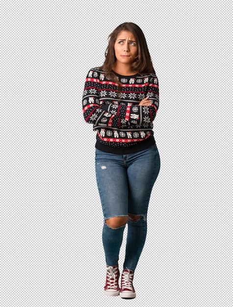 Mujer de cuerpo completo con una camiseta de navidad pensando en una idea.