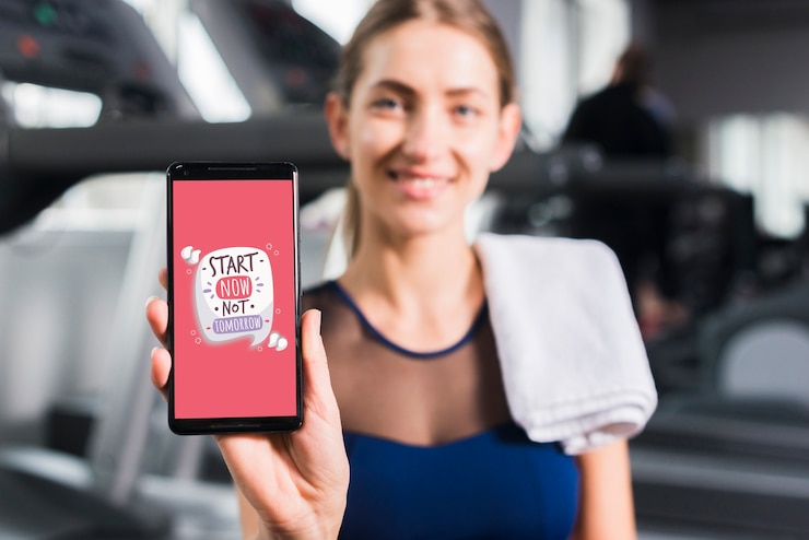 PSD mujer deportiva feliz presentando mockup de smartphone