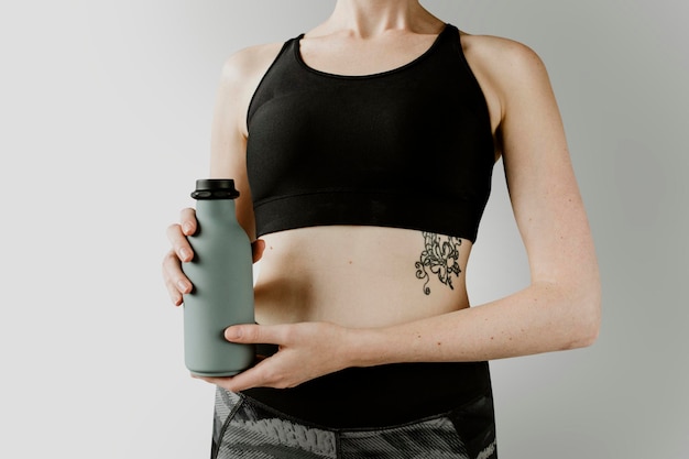 Mujer deportiva con una maqueta de botella de agua