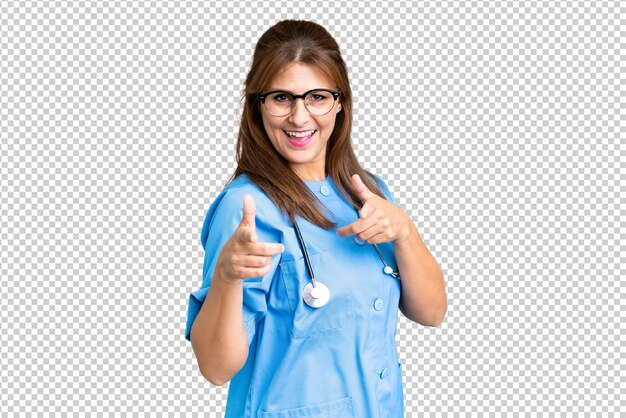 PSD mujer enfermera de mediana edad sobre un fondo aislado señalando hacia el frente y sonriendo