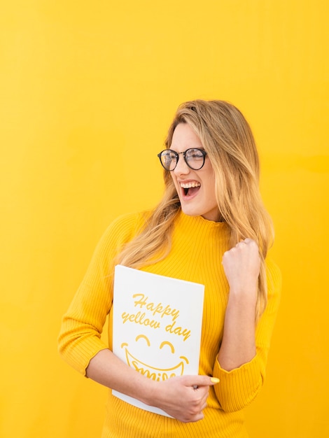 Mujer feliz con maqueta de concepto amarillo