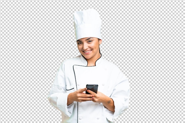 Mujer joven chef sobre fondo de llave cromada aislada enviando un mensaje con el móvil