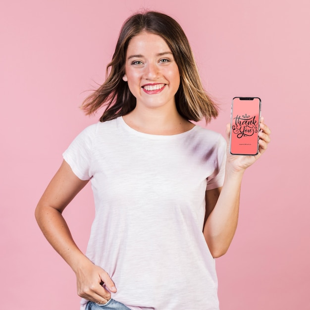 PSD mujer joven sonriente que sostiene una maqueta del teléfono celular