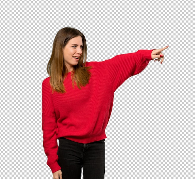Mujer joven con suéter rojo apuntando lejos
