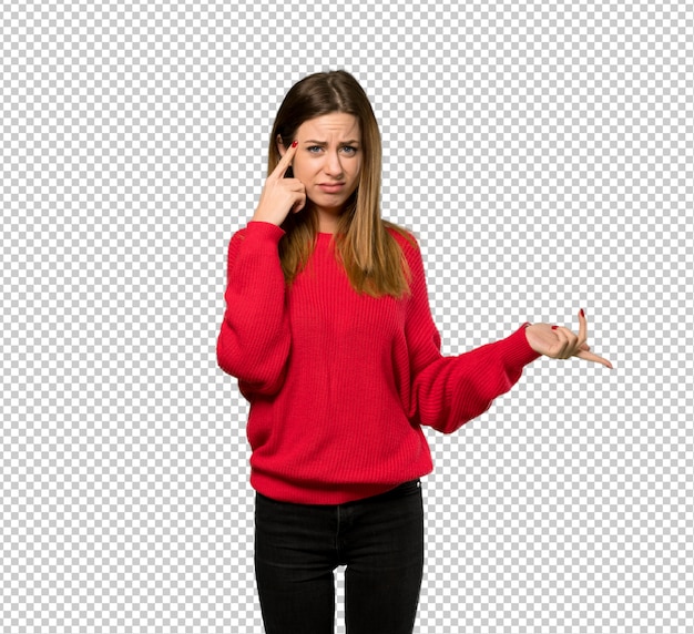 Mujer joven con suéter rojo haciendo el gesto de locura poniendo el dedo en la cabeza