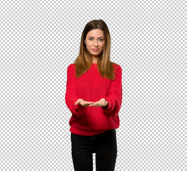 Mujer joven con suéter rojo sosteniendo copyspace imaginario en la palma para insertar un anuncio