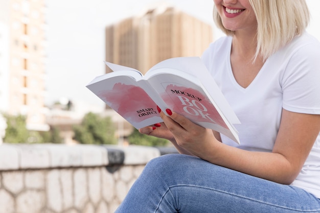 Mujer leyendo un libro en la calle cerrar