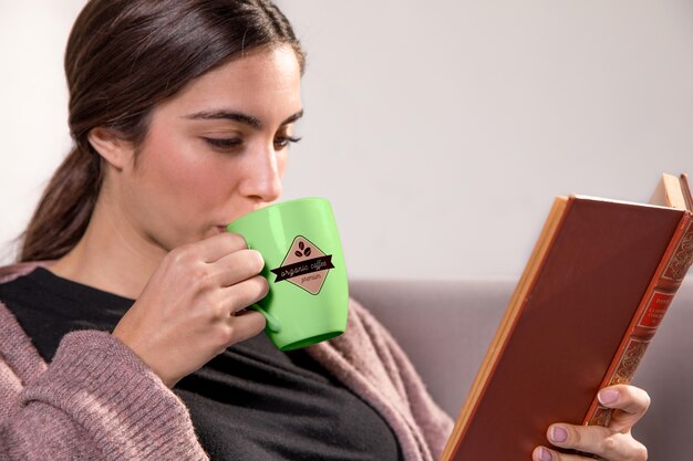 Mujer con libro y taza verde