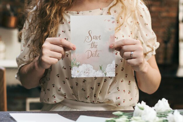 Mujer con una maqueta de tarjeta de invitación de boda