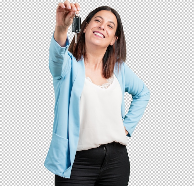 Mujer de mediana edad, feliz y sonriente, sosteniendo las llaves del auto, confiada