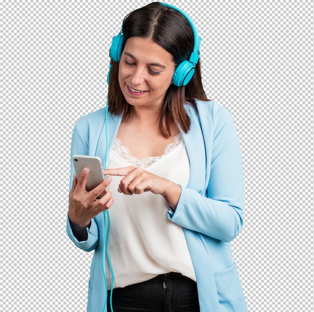 Mujer de mediana edad relajada y concentrada, escuchando música con su teléfono móvil.