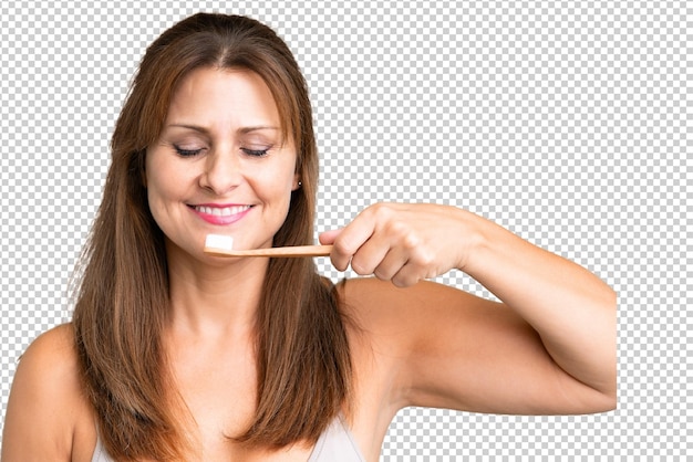 Mujer de mediana edad sobre fondo aislado con un cepillo de dientes y expresión feliz