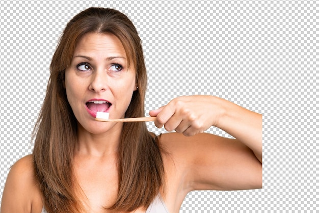 Mujer de mediana edad sobre un fondo aislado con un cepillo de dientes