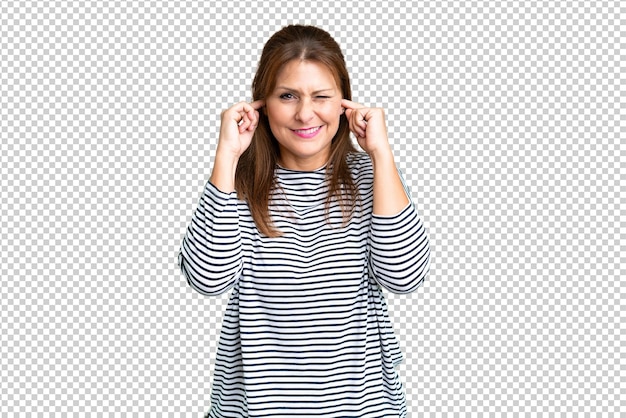 Mujer de mediana edad sobre fondo aislado frustrado y cubriendo las orejas