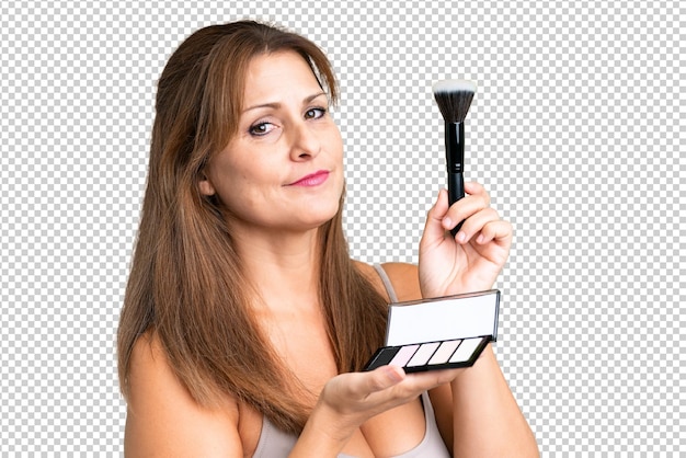 Mujer de mediana edad sobre fondo aislado con paleta de maquillaje