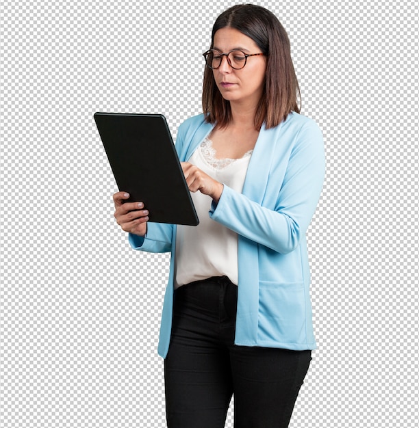 Mujer de mediana edad sonriente y confiada, sosteniendo una tableta, usándola para navegar por Internet y ver las redes sociales, la comunicación