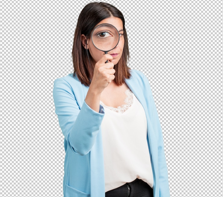 PSD mujer de mediana edad sorprendida y con los ojos abiertos mirando a través de una lupa, estudiando algo, encontrando evidencia