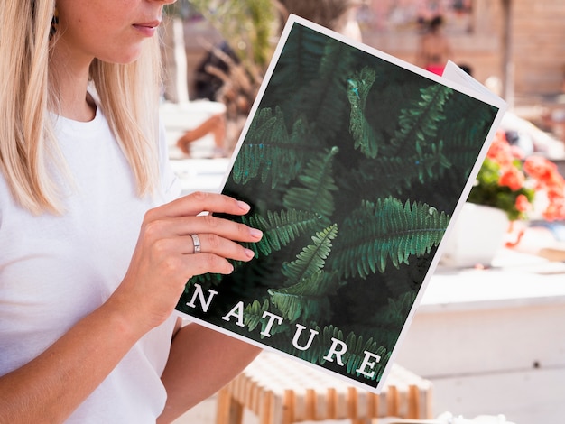 Mujer mirando en un libro de naturaleza simulacro