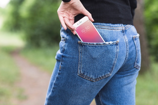 Mujer en naturaleza con smartphone en el bolsillo