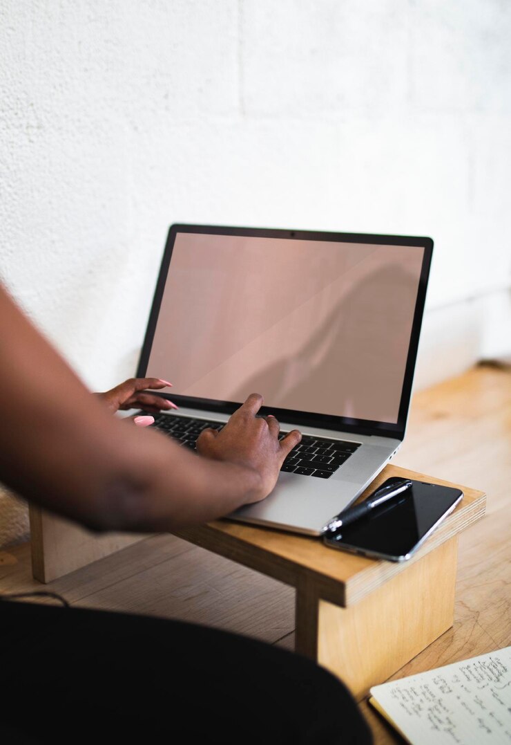 PSD mujer negra usando una computadora portátil en una mesa de madera