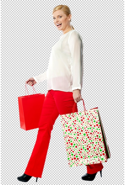 una mujer con pantalones rojos está llevando una bolsa de compras