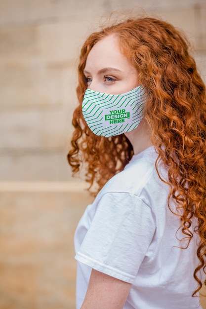 Mujer de pelo rojo con mascarilla protectora médica