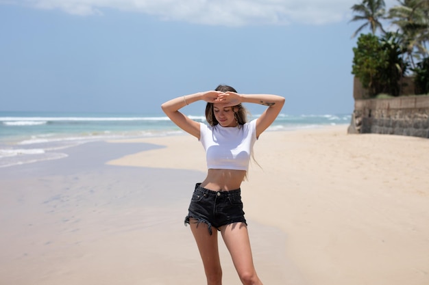 Mujer en la playa con las manos sobre los ojos