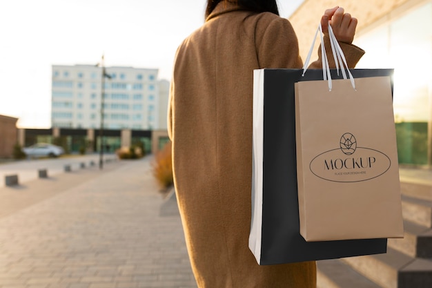 Mujer que sostiene el bolso de compras lujoso al aire libre
