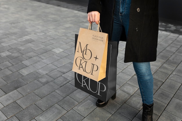 PSD mujer que sostiene el bolso de compras lujoso al aire libre