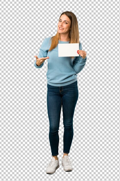 Mujer rubia con camisa azul sosteniendo un cartel vacío para insertar un concepto