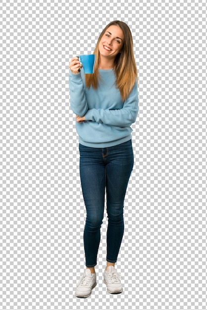 Mujer rubia con camisa azul sosteniendo una taza de café caliente